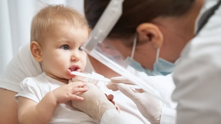 Infant receiving early dental checkup with parent nearby